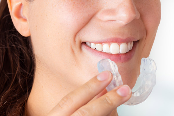 Woman wearing orthodontic silicone trainer. Invisible braces ali
