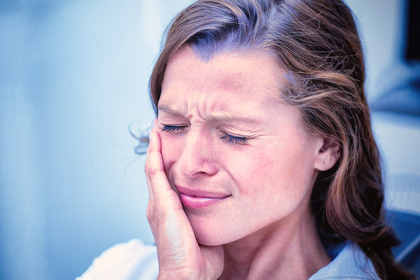Unhappy woman having a toothache  in dental clinic