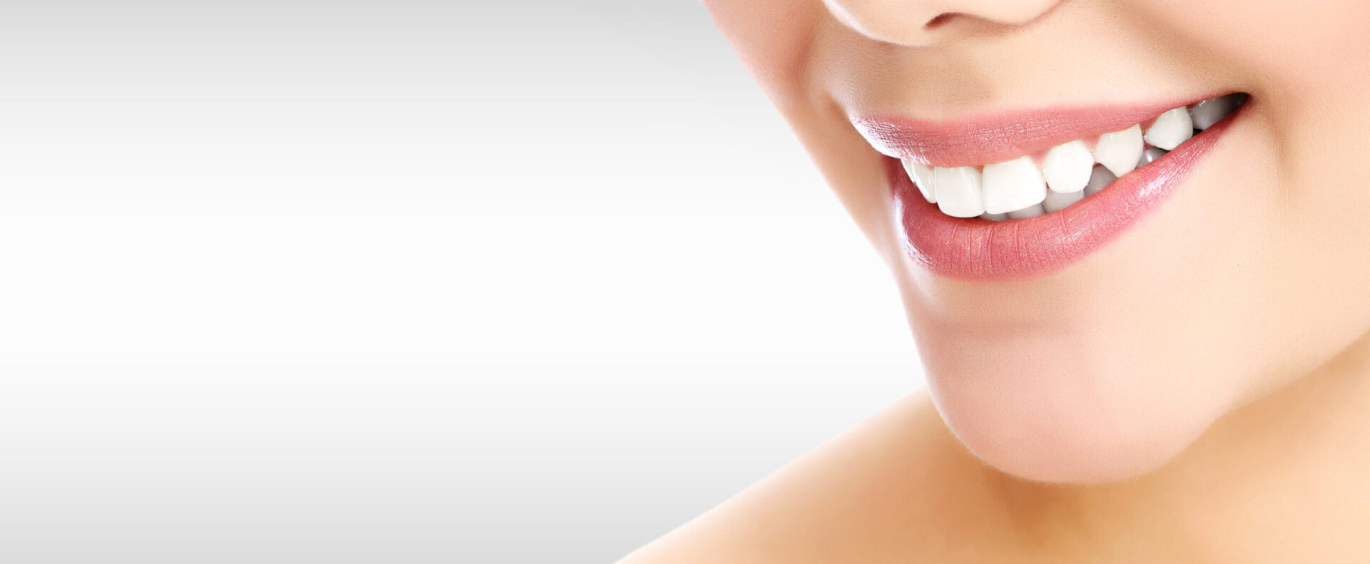 Pretty woman smiling against a grey background with copyspace